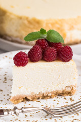 Slice Of Classical New York Cheesecake with raspberries On White Plate. Closeup View. Home bakery concept