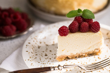 Slice Of Classical New York Cheesecake with raspberries On White Plate. Closeup View. Home bakery concept