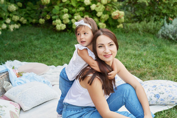 family mom and child daughter at a picnic in the garden in summer