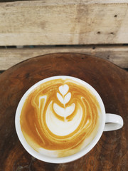 a cup of latte art coffee on wooden background                              