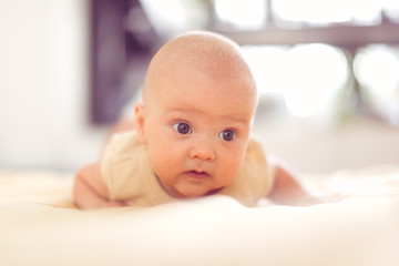 4 month baby on bed in bedroom in bright interior