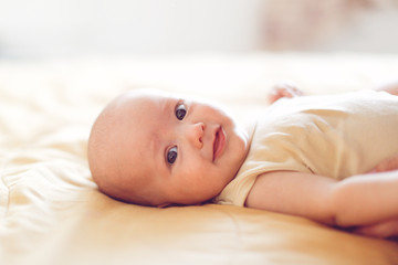 4 month baby on bed in bedroom in bright interior