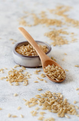Brown rice in a wooden bowl with a  spoon
