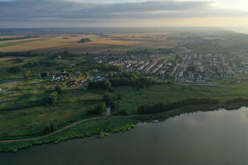 Drone aerial perspective view on housing estate in touristic Mielno city at Jamno Lake during sunset.