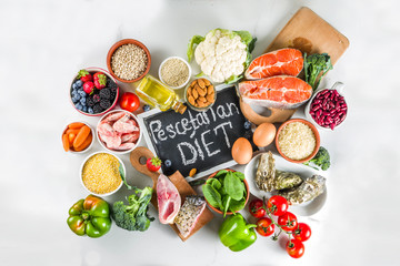 Pescetarian diet plan ingredients, healthy balanced grocery food, fresh fruit, berries, fish and shellfish clams, white marble background copy space 