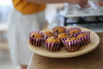 Girl puts ready-made pastries on wooden tray