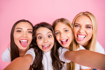 Fototapeta premium Self-portrait of four nice attractive lovely charming comic playful cheerful cheery long hsired girls having fun spending free time fooling maternity isolated on pink pastel background