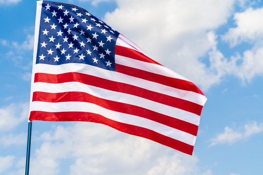 American flag waving in the wind against blue sky