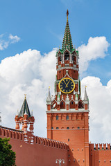 Spasskaya tower of Moscow Kremlin on a background of blue sky with white clouds in sunny day