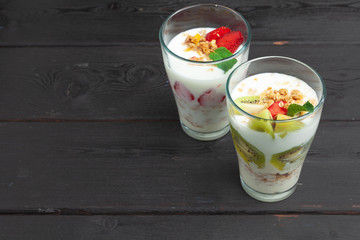 Oatmeal with yogurt and berries on a black wooden background. Top view. Healthy breakfast.