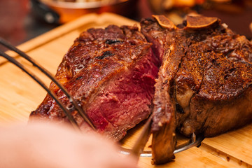 Delicious t-bone steak on a wooden board.