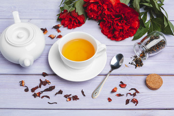 Cup of green tea on table with fresh peony flowers