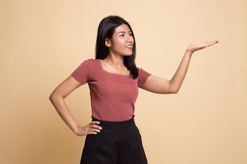 Young Asian woman present with her hand.