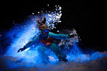 Fototapeta na wymiar Active female snowboarder dressed in a orange and blue sportswear makes tricks on the snow