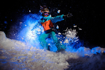 Female snowboarder dressed in a orange and blue sportswear making tricks on the snow