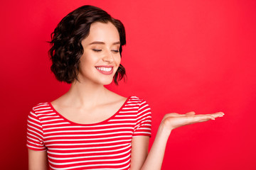 Close-up portrait of her she nice attractive lovely lovable charming cute cheerful cheery content wavy-haired girl holding sale discount ad advert isolated over bright vivid shine red background