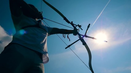 Sunlit sky and an archer in the process of aiming