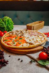 Sliced delicious tasty pizza with vegetables on wooden table.