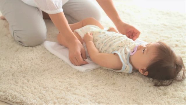 Mother changing diaper of baby