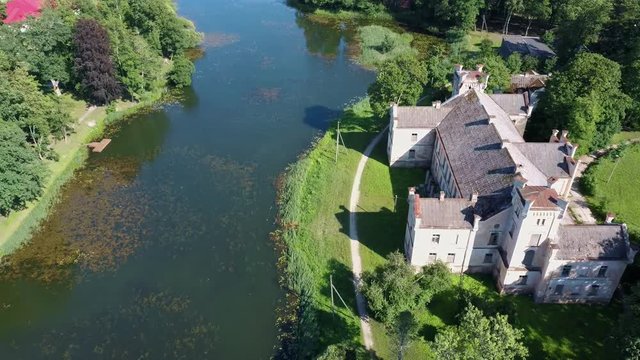 Aerial Dron Shot of the Cirava Lutheran Church Aizpute  Latvia, Sunny Summer Day. Flaying Above the  Church and Manor Castle.