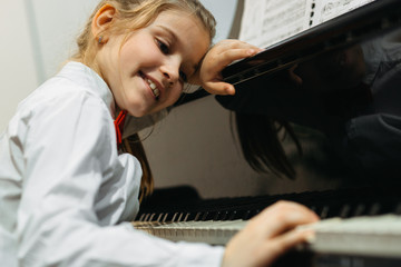 little girl daydreaming over concert piano