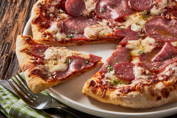 Tasty regional Italian salami pizza with herbs