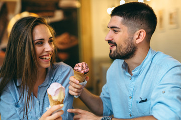 man and woman eating ice cream in cafe