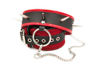 Leather handcuffs and collar with spikes connected by a chain isolated on white background.