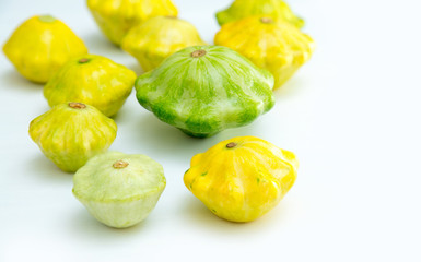 Squash vegetable. Group of green and yellow pattypan squashes, on white table background.