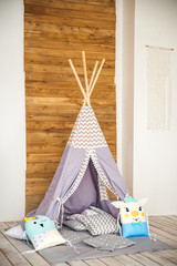 Children's room in a rustic style. Blue wigwam in a children's room. Interior details of a bright Scandinavian nursery. © Nelly