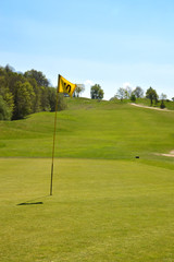 Obraz premium Putting green with golf flagstick on a golf course