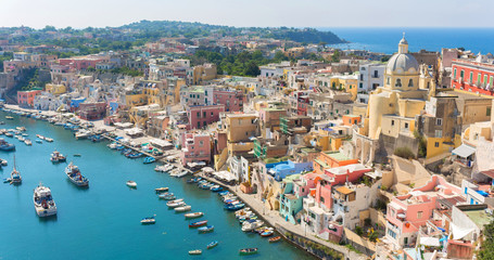 Fototapeta na wymiar Beautiful panorama of Procida island a sunny summer day in Italy (Campania). The Marina Corricella is famous for its colorful houses and boats. This island is located between Naples and Ischia – Image