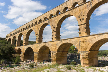 Fototapeta na wymiar Beautiful view of Pont du Gard, the highest Roman aqueduct in Europe, a sunny summer day. This three-tiered bridge is located in Provence, in south of France, over the Gardon river. – Image