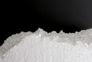 Styrofoam clouseup on darck background. Foam plastic texture.