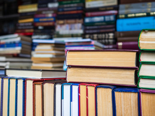 Books with the turned yellow pages stand the friend on the friend in a heap. The shelf with books for sale