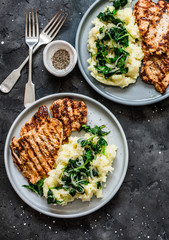 Turkey grilled chop and mashed potatoes with creamy spinach on a dark background, top view. Comfort home cooked food