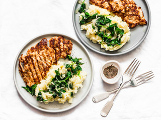 Turkey grilled chop and mashed potatoes with creamy spinach on a light background, top view. Comfort home cooked food