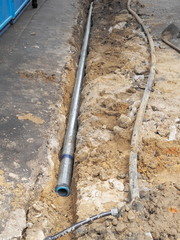 New aluminum water pipe and old plastic water pipe on the ground, maintenance water supply working on site.