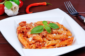 Pasta with tomato sauce, parmesan and basil in a plate