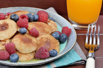 Pancakes with berries and orange juice