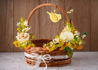 Fototapeta na wymiar Decorative basket decorated with flowers on a wooden background