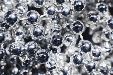 Silver balls on a string. Garland of beads.Background