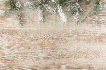 Christmas tree branch with pine cones on rustic wooden table. Winter background with copy space. Top view. Flat lay