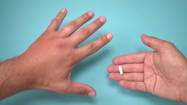 Male hand stung by bee and medication for swelling next to it. Hand swelling, inflammation, redness are signs of infection. Insect bite and pills on blue background