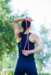 Athletic girl working out in a park. Beautiful embossed back.