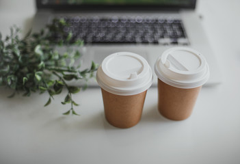glasses with coffee and laptop on a white table