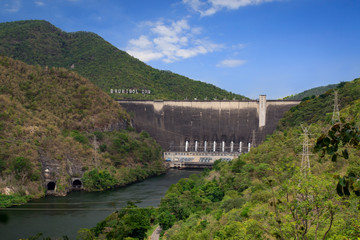 Image of front view of Bhumibol dam in Tak. Hydro Power Electric Dam and is the first multipurpose dam in thailand and is water storage for agriculture and electricity.. The curved concrete dam.