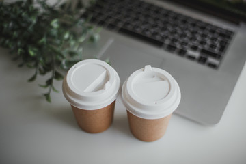 glasses with coffee and laptop on a white table