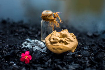 Activated charcoal face mask consisting of bentonite clay or fuller's earth or multani mitti or mulpani mitti well mixed with baking soda and coconut oil. On a wooden surface with entire constituents.