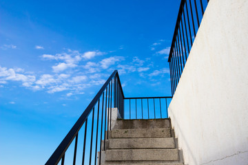 outdoor staircase and railing leading to blue skies